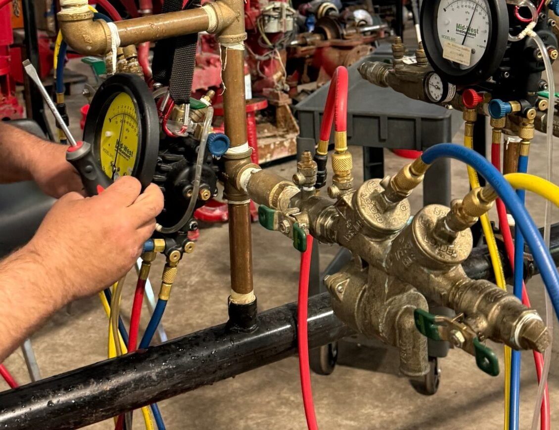 Plumber using a backflow testing device